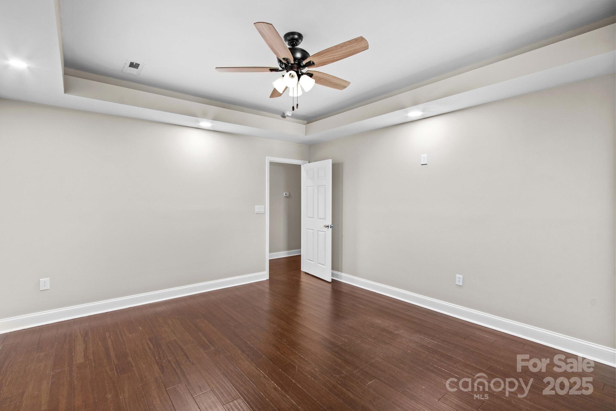 1493 Swicegood Road Linwood, NC 27299 - Photo 33 of 45 an empty room with wooden floor and ceiling fan