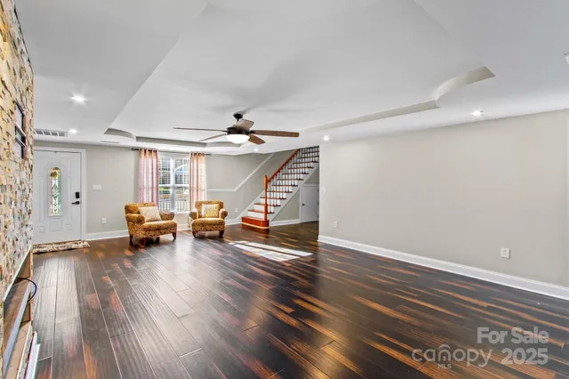 a view of a living room hardwood floor and a ceiling fan