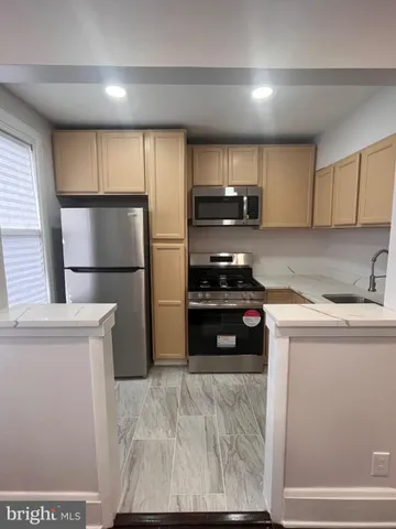 a kitchen with a refrigerator a stove a microwave and cabinets