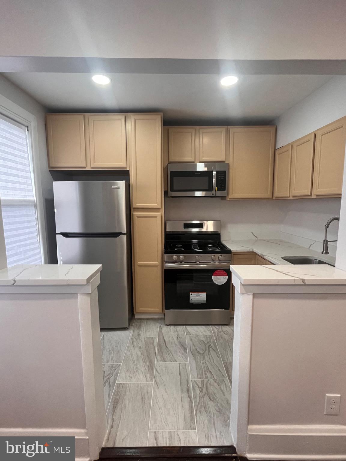 4027 Annellen Road Baltimore, MD 21215 - Photo 2 of 16 a kitchen with a refrigerator a stove a microwave and cabinets