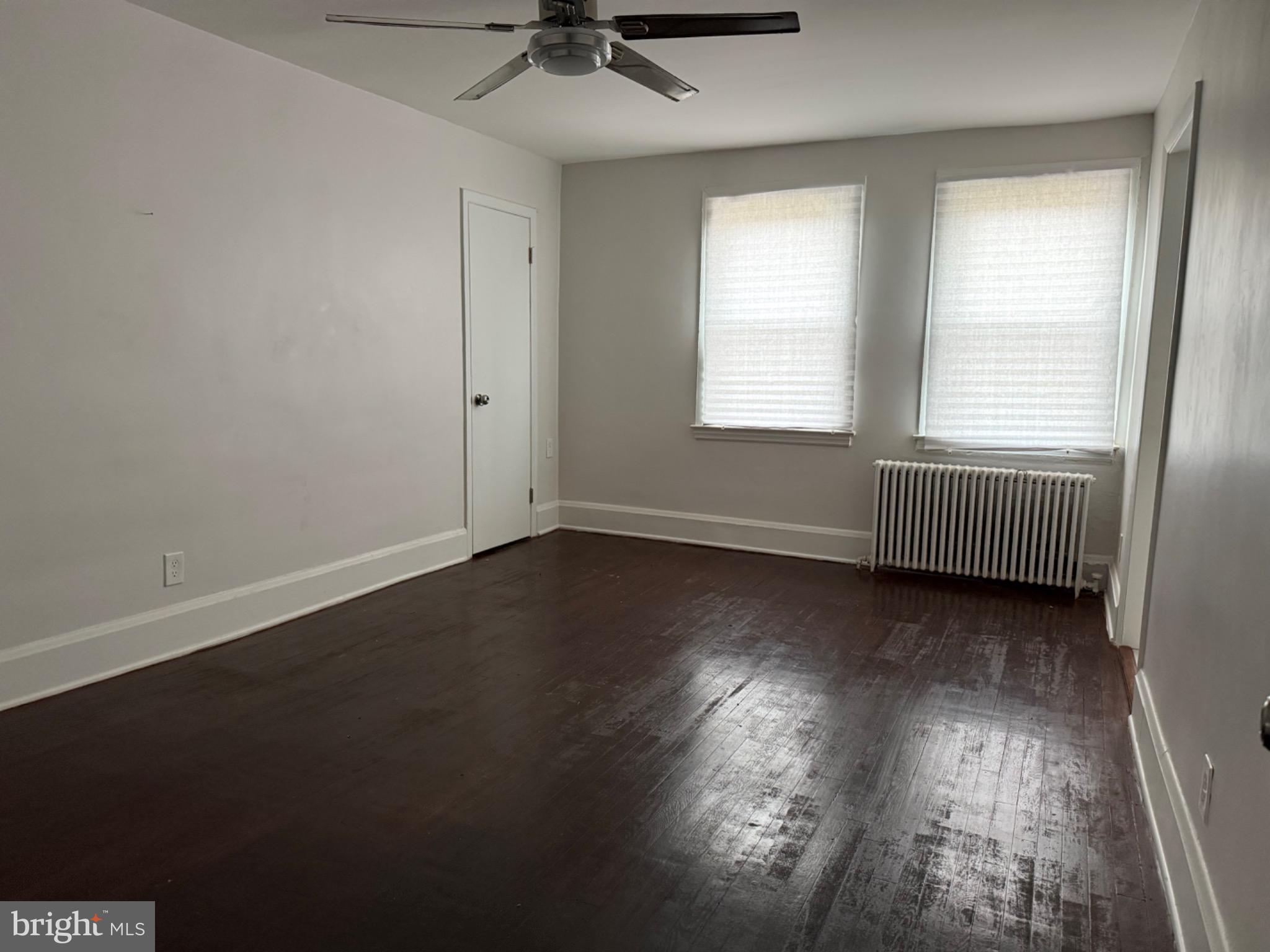 4027 Annellen Road Baltimore, MD 21215 - Photo 7 of 16 an empty room with wooden floor and windows