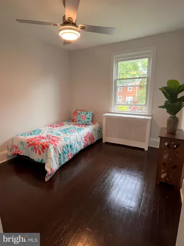 an empty room with wooden floor cabinet and windows