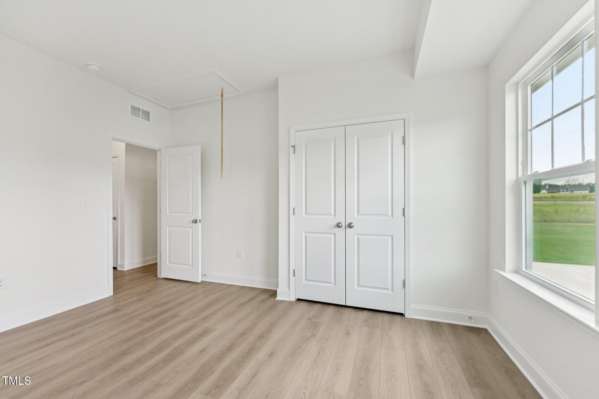 214 Alden Way Angier, NC 27501 - Photo 11 of 35 a view of an empty room with wooden floor and a window