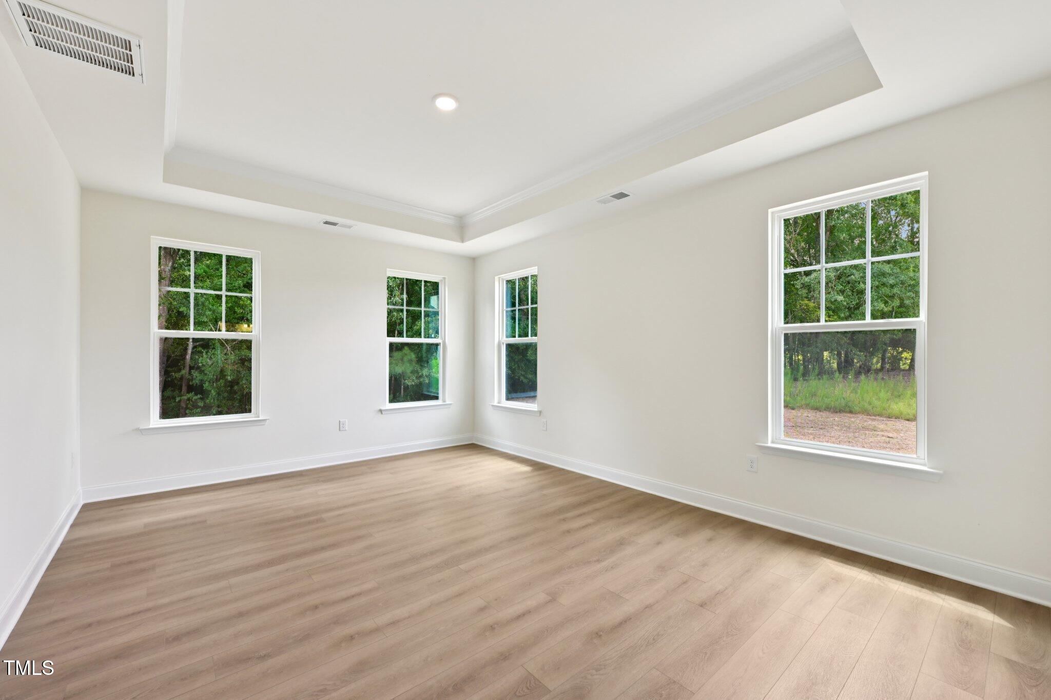 214 Alden Way Angier, NC 27501 - Photo 17 of 35 an empty room with wooden floor and windows