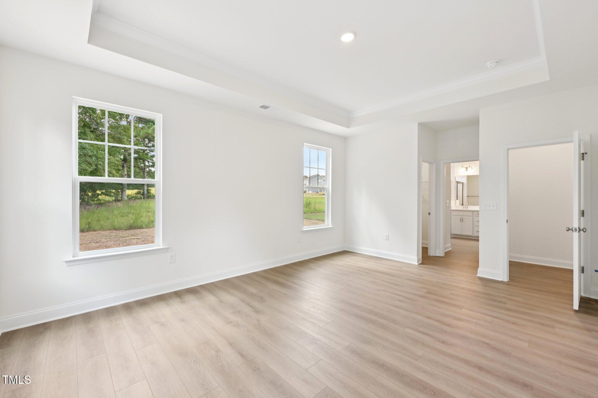 214 Alden Way Angier, NC 27501 - Photo 19 of 35 an empty room with wooden floor and windows