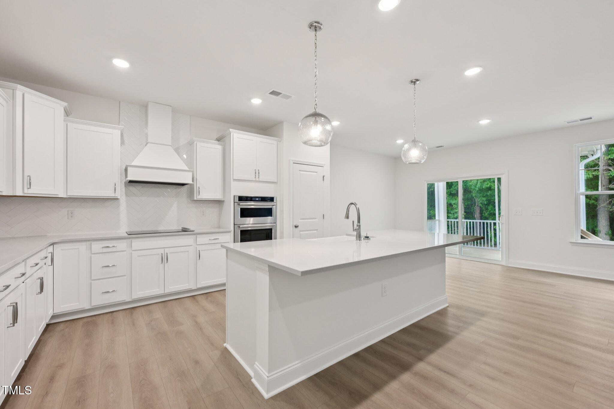 214 Alden Way Angier, NC 27501 - Photo 3 of 35 a large kitchen with kitchen island a sink stainless steel appliances and cabinets