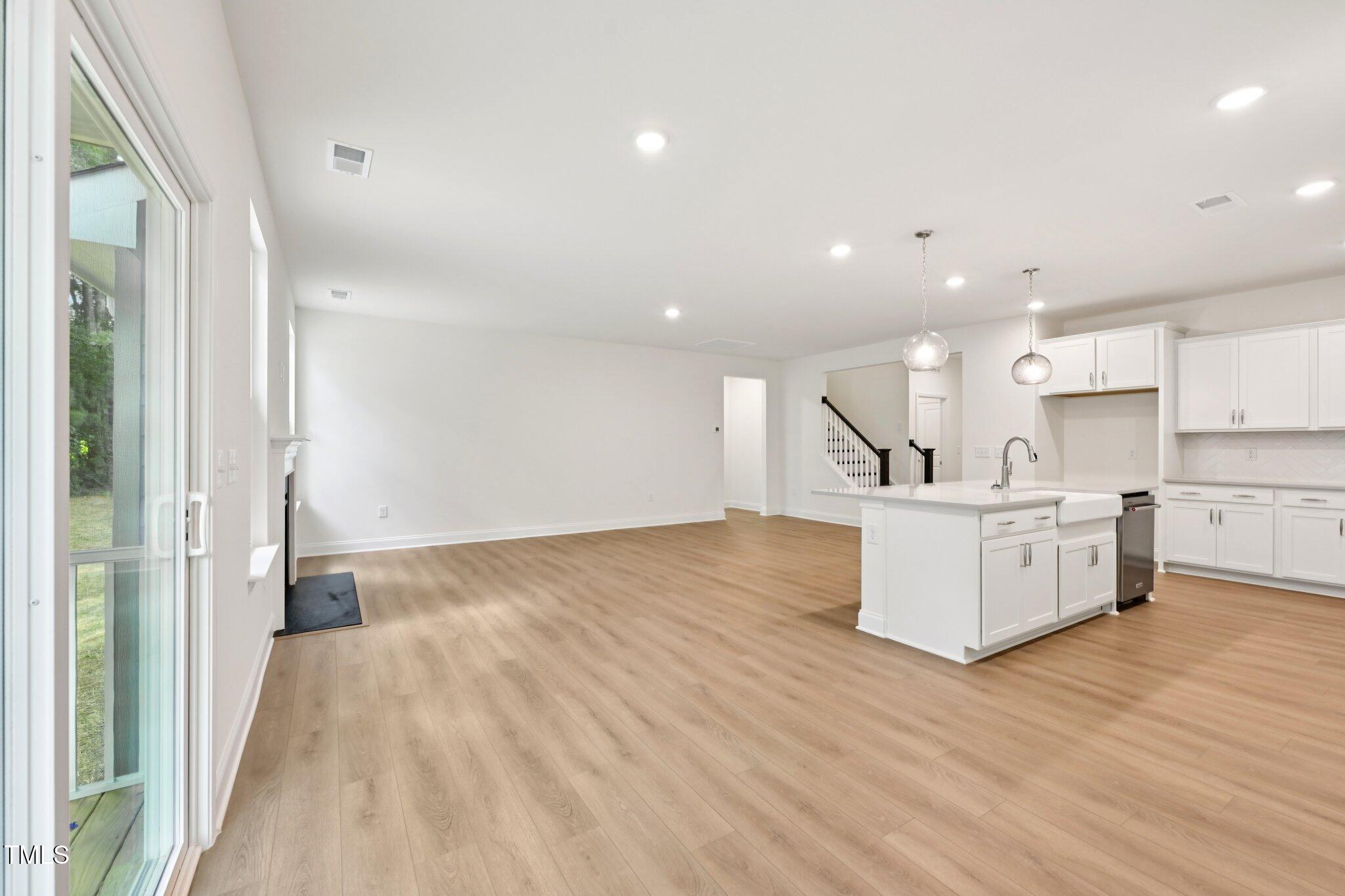 214 Alden Way Angier, NC 27501 - Photo 5 of 35 a view of kitchen with kitchen island microwave oven stove and white cabinets with wooden floor