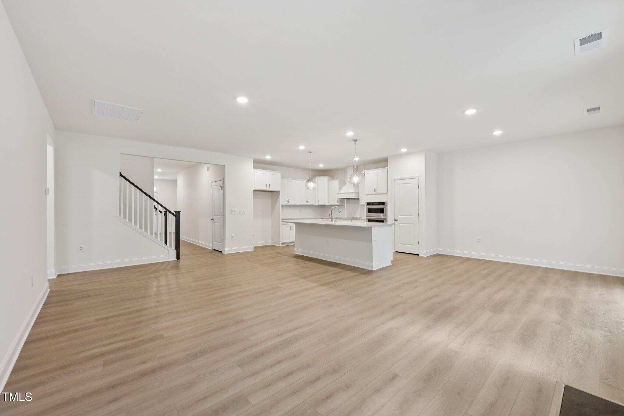 214 Alden Way Angier, NC 27501 - Photo 6 of 35 a view of kitchen with kitchen island wooden floor center island and stainless steel appliances