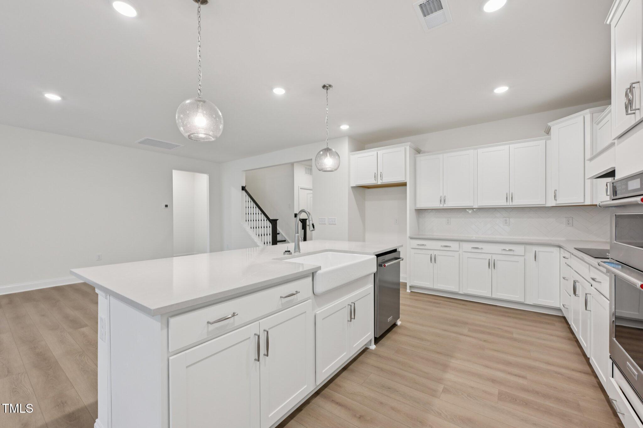 214 Alden Way Angier, NC 27501 - Photo 8 of 35 a kitchen with white cabinets and white appliances
