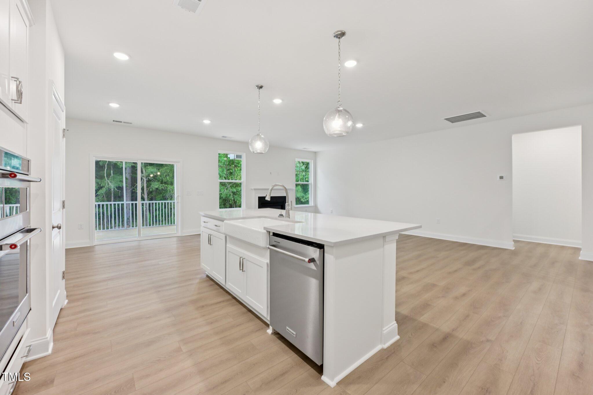 214 Alden Way Angier, NC 27501 - Photo 9 of 35 a large kitchen with stainless steel appliances a large counter top and a wooden floors