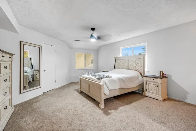 a spacious bedroom with a bed and a cabinets