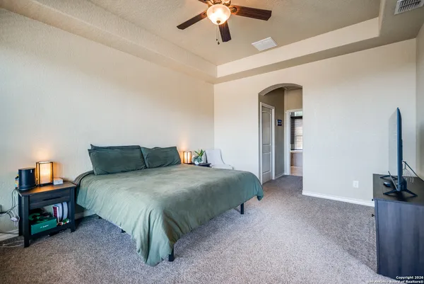 a spacious bedroom with a bed and a flat screen tv