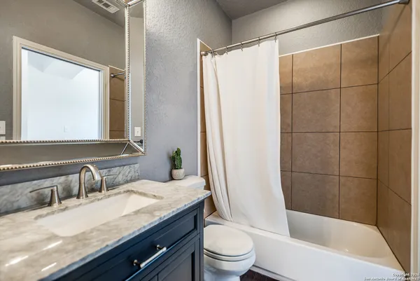 a bathroom with a granite countertop sink toilet and shower