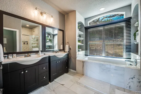 a bathroom with a tub sink and mirror
