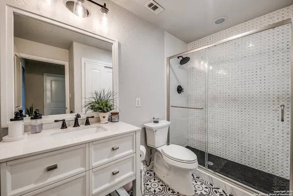 a bathroom with a sink a toilet and shower