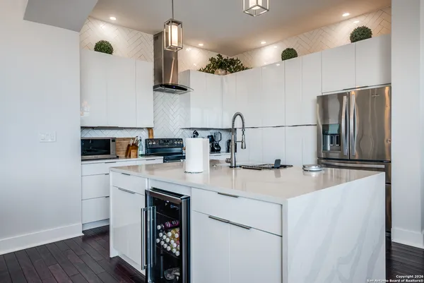 a kitchen with kitchen island a sink stainless steel appliances and cabinets