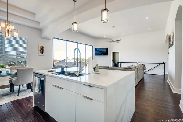 a kitchen with a sink a counter space and a dining table with wooden floor