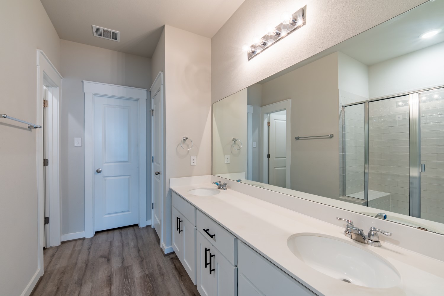147 A Waterside Road, Unit A Buda, TX 78610 - Photo 11 of 21 Double vanity and a spacious shower offer functional elegance in this well-appointed bathroom.