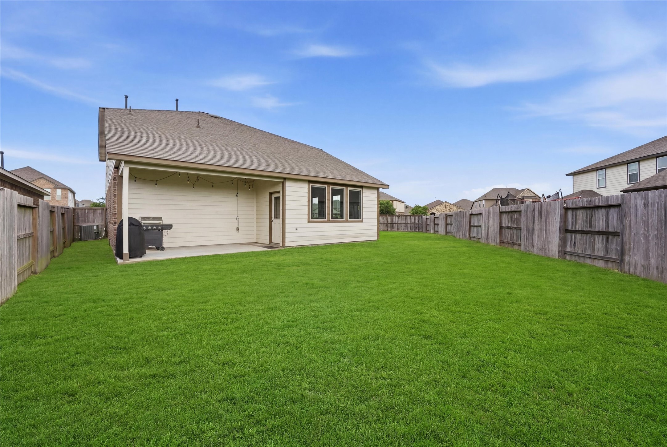2130 Shellbark Way La Marque, TX 77568 - Photo 20 of 30 Spacious backyard with well-maintained lawn, a covered patio area, and wooden fencing, perfect for outdoor activities and entertaining.