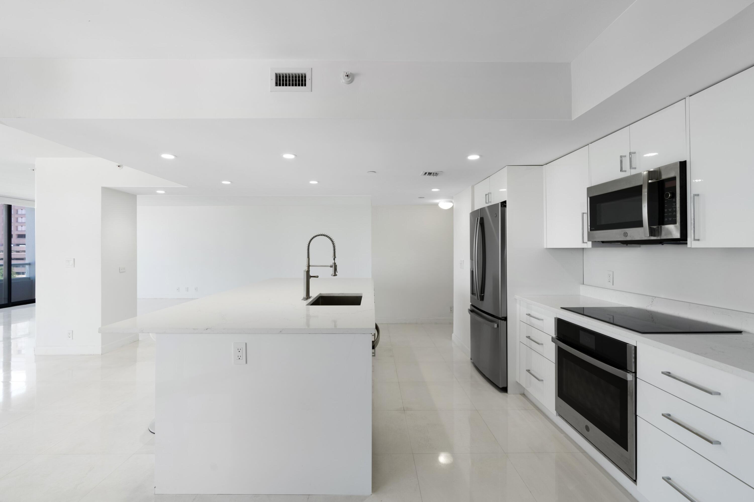 529 South Flagler Drive, Unit 6E West Palm Beach, FL 33401 - Photo 13 of 24 a large kitchen with stainless steel appliances kitchen island a large counter top space and cabinets