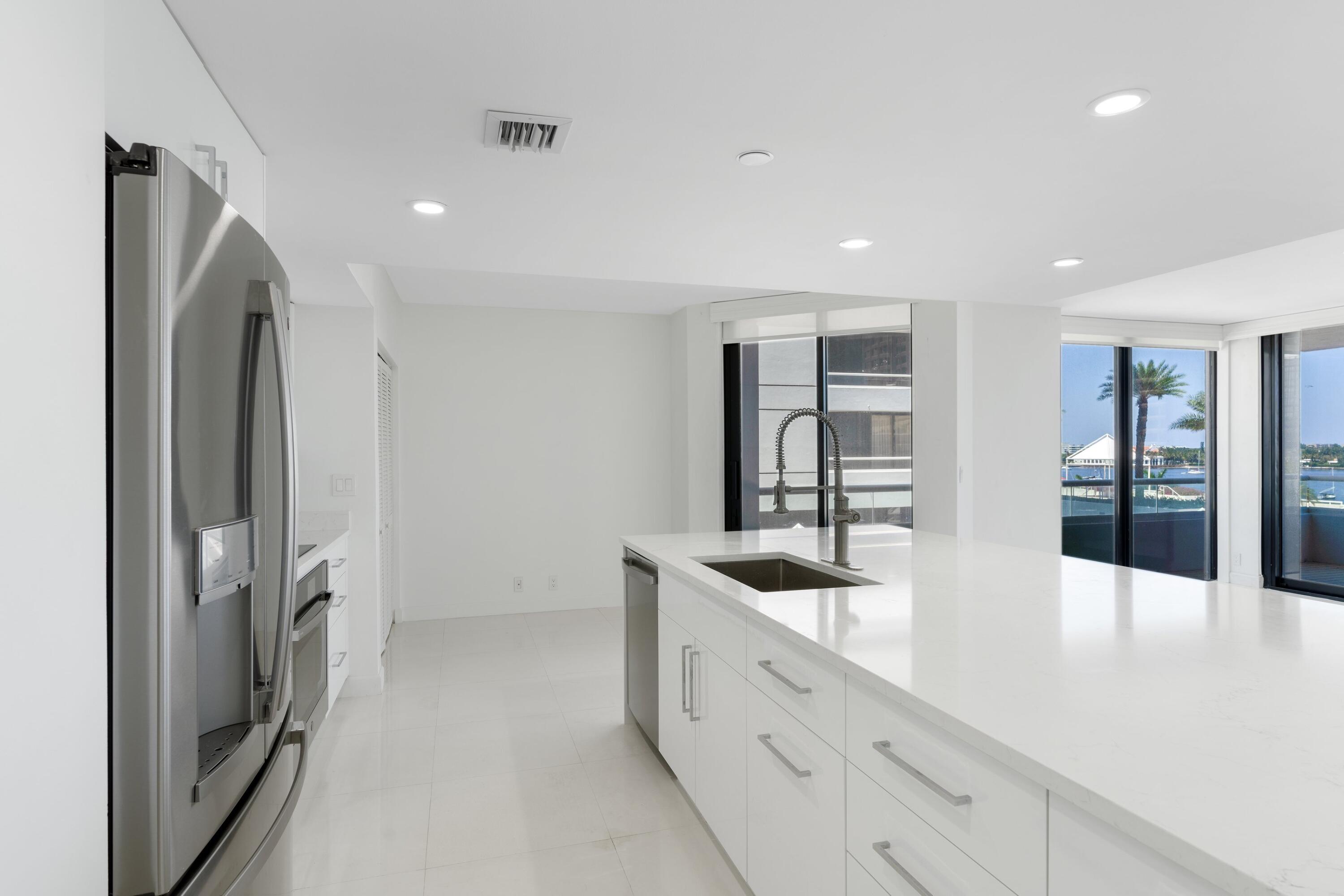 529 South Flagler Drive, Unit 6E West Palm Beach, FL 33401 - Photo 6 of 24 a kitchen with stainless steel appliances granite countertop a refrigerator and a sink