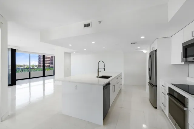 a view of a kitchen with a sink and stainless steel appliances
