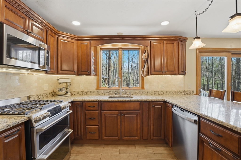 4 Charnock Circle Rutland, MA 01543 - Photo 8 of 42 a kitchen with stainless steel appliances granite countertop a stove and a sink