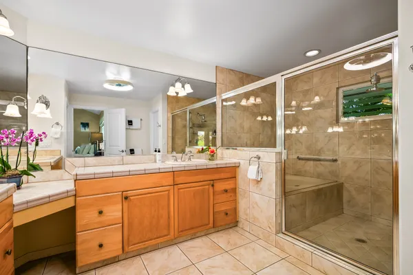 a bathroom with a granite countertop sink mirror and shower