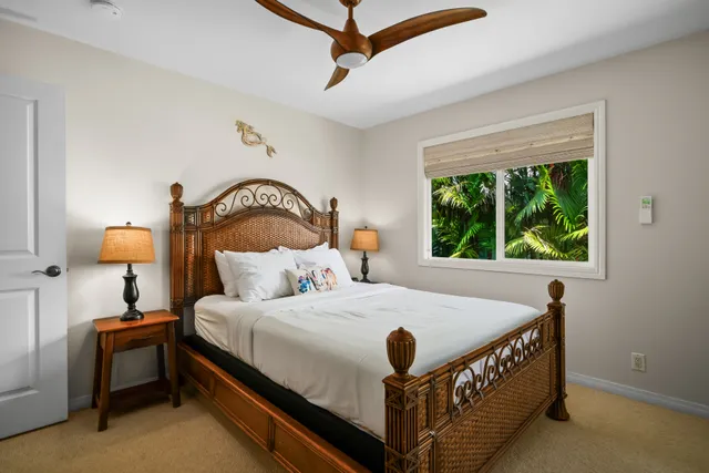 a bedroom with a bed chandelier and a window