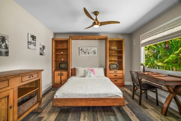 a bedroom with a bed and wooden floor