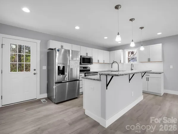 a kitchen with stainless steel appliances a refrigerator sink and microwave