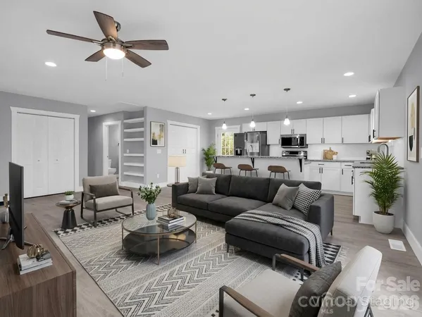 a living room with furniture kitchen view and a potted plant