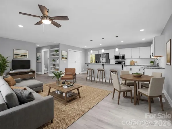a living room with furniture kitchen view and a window
