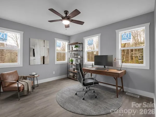 a view of a livingroom with workspace and a window