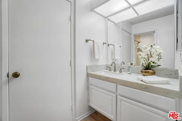 a bathroom with a granite countertop sink and a mirror