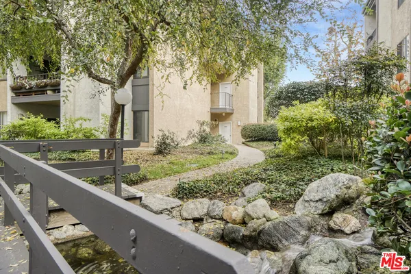 a view of a house with a yard and large tree