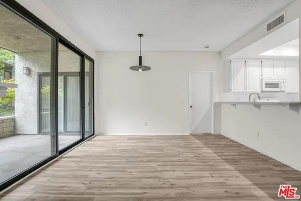 a view of a kitchen with wooden floor and a window