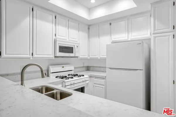 a kitchen with sink a microwave and refrigerator