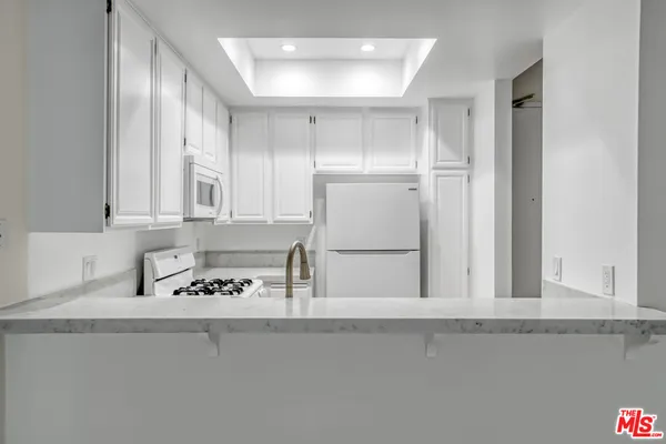 a kitchen with cabinets and white appliances