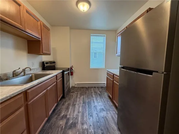 a kitchen with sink a refrigerator and wooden floor