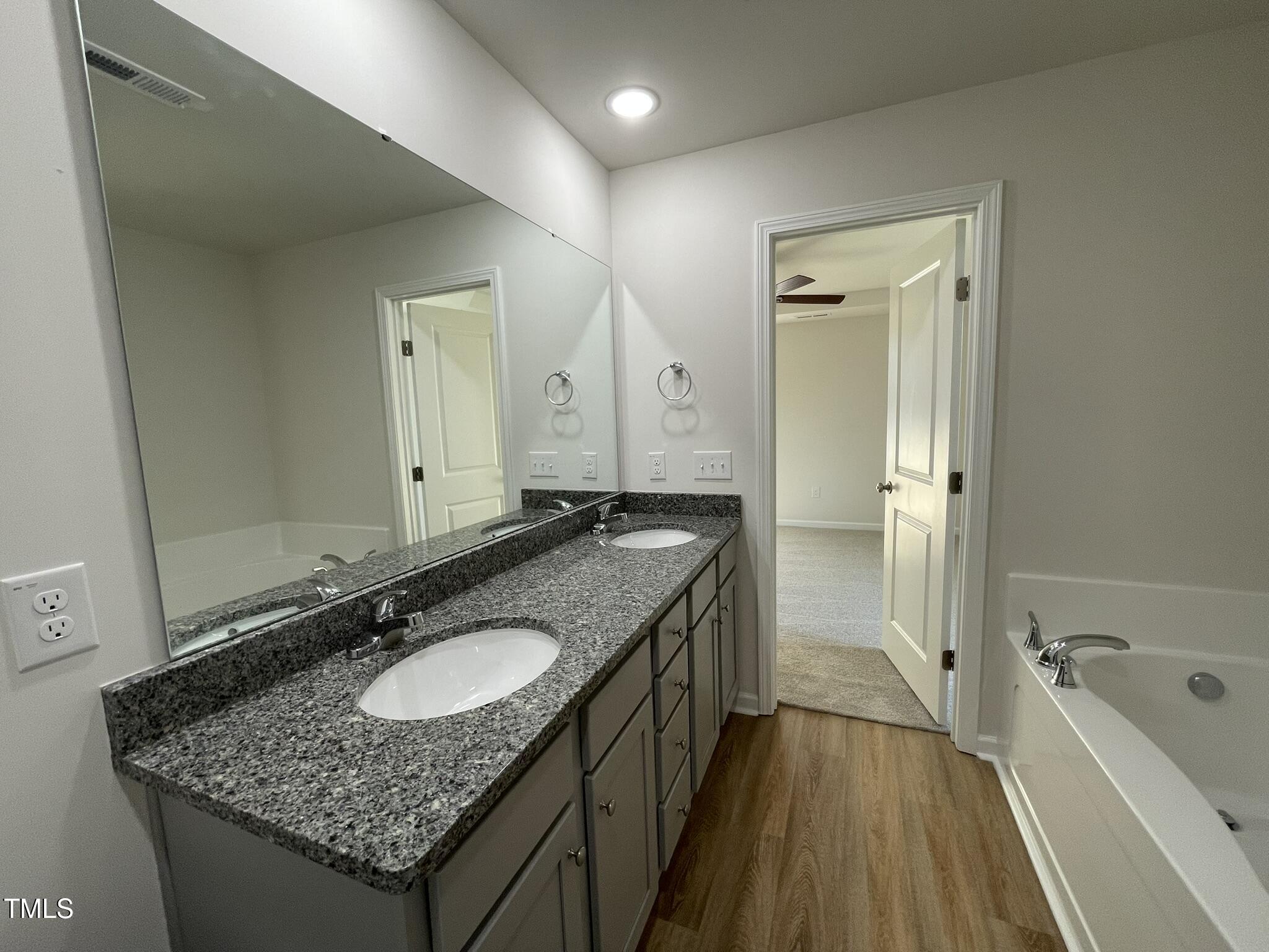 12 Flatland Drive Princeton, NC 27569 - Photo 13 of 20 a bathroom with a granite countertop sink a mirror a bathtub and shower