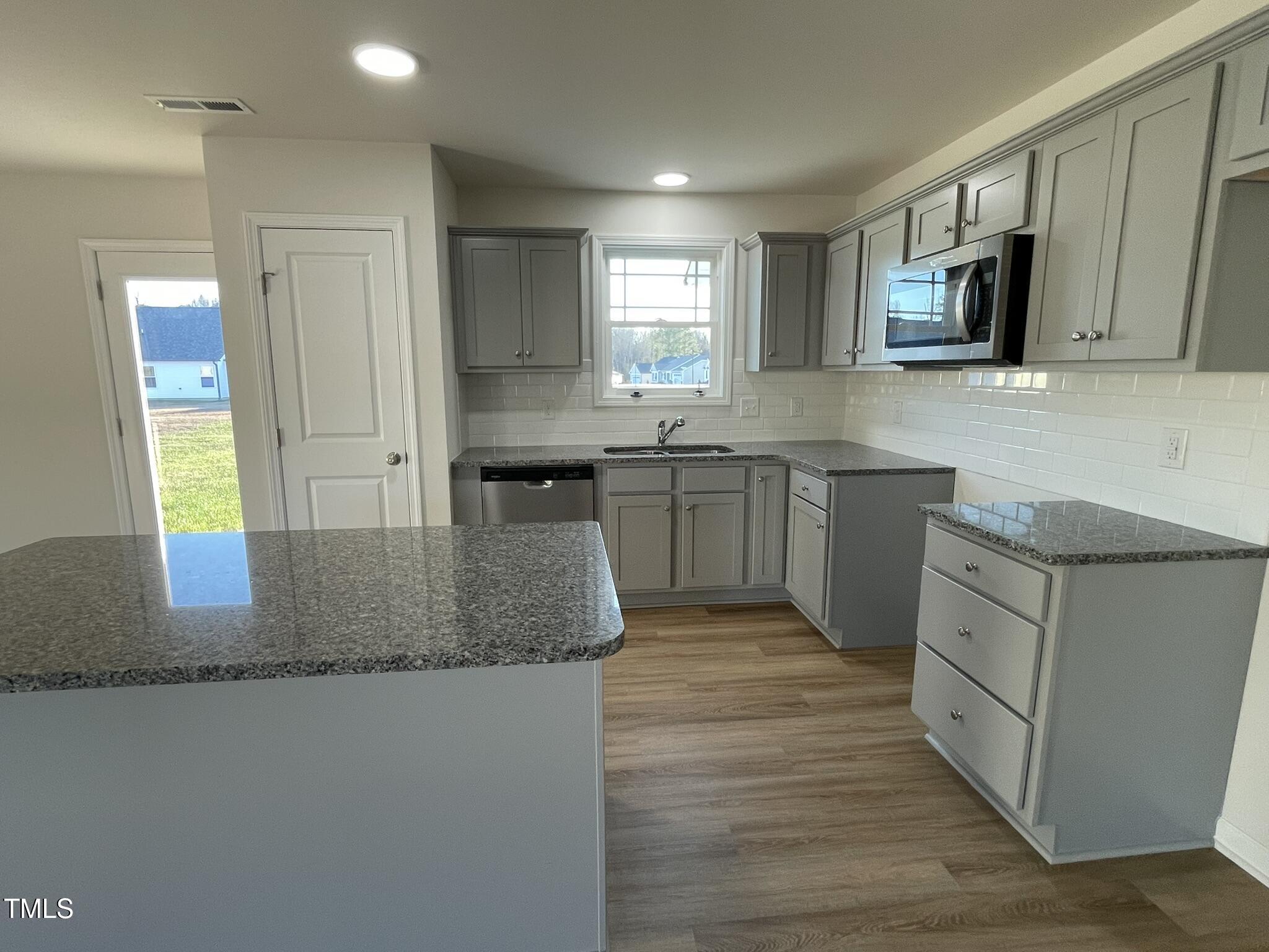 12 Flatland Drive Princeton, NC 27569 - Photo 3 of 20 a kitchen with stainless steel appliances granite countertop a sink stove microwave and refrigerator