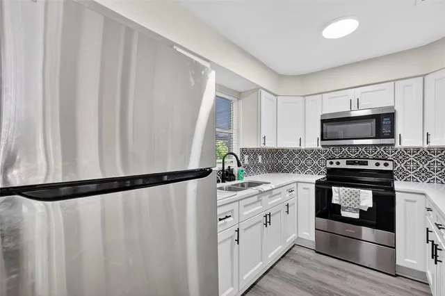 a kitchen with a sink a microwave and cabinets