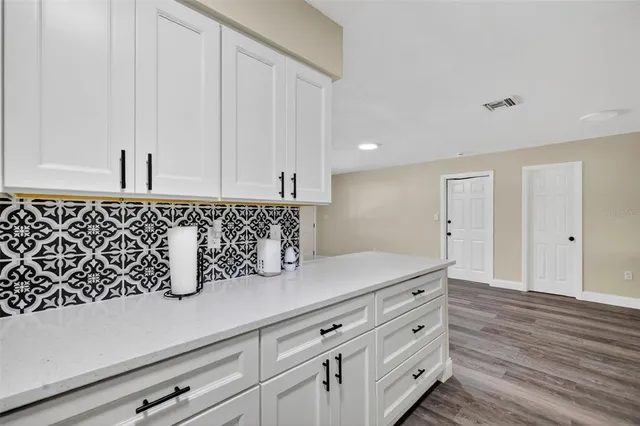 a view of cabinets a wooden floor and a sink