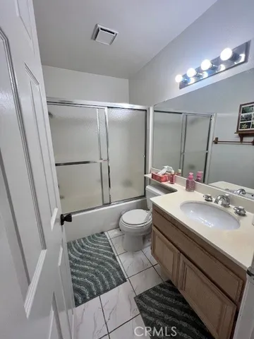 a bathroom with a sink a toilet a mirror and shower
