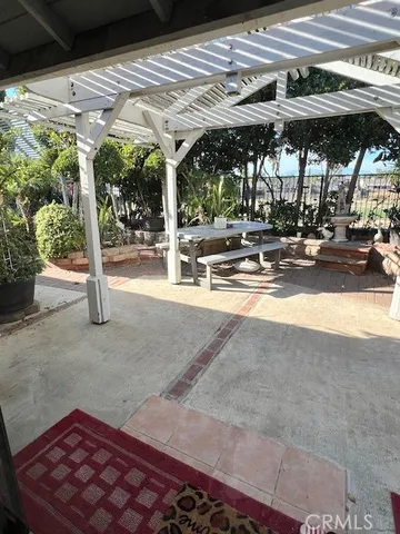 a view of a patio with table and chairs under an umbrella