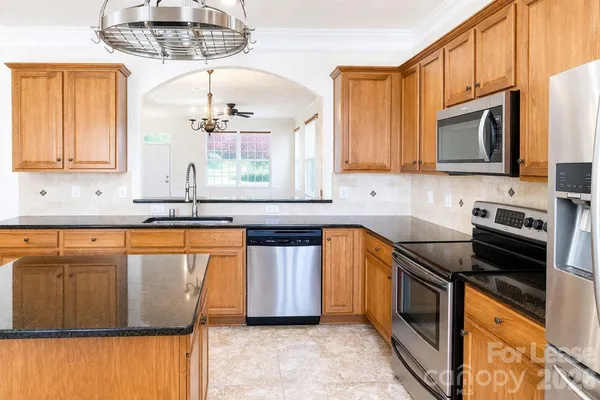 a kitchen with stainless steel appliances granite countertop a sink stove and microwave