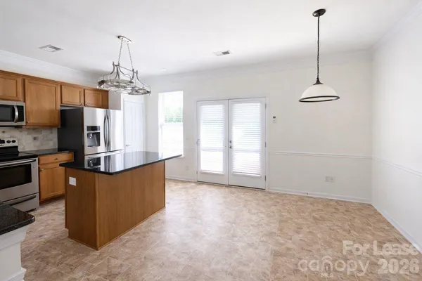 a kitchen with stainless steel appliances granite countertop a refrigerator a sink a stove a microwave and island