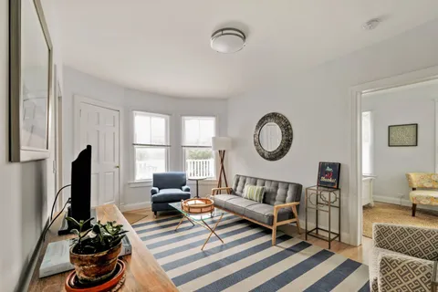 a living room with furniture a rug and a window