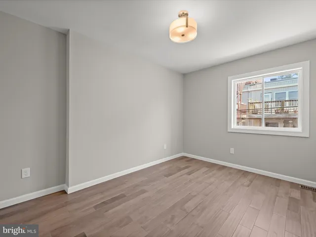 wooden floor in an empty room with a window